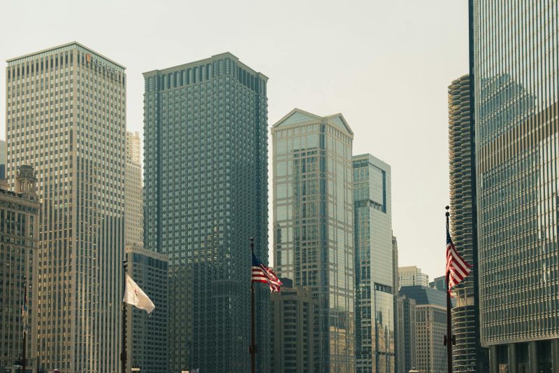 Chicago skyline featuring towering skyscrapers and American flags in the foreground.