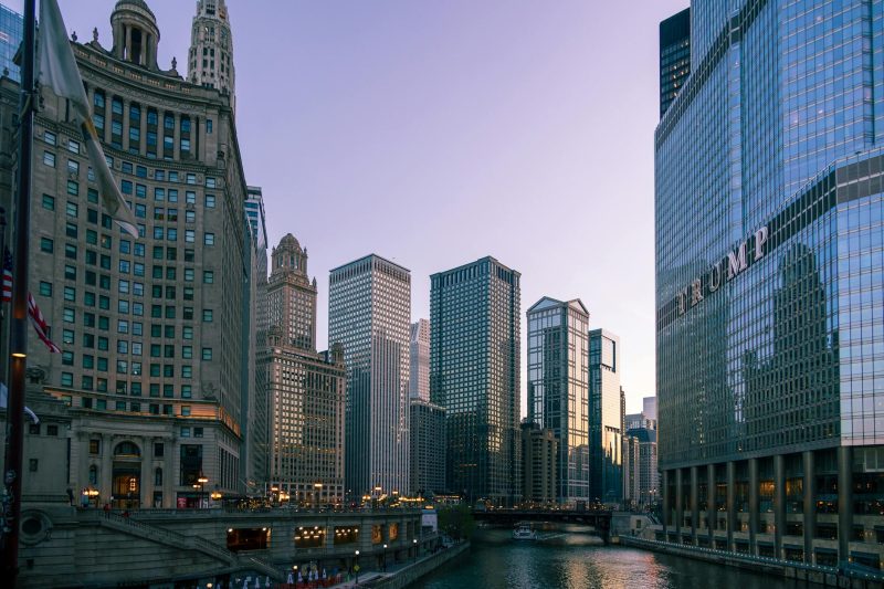Chicago's skyline at dusk, showcasing modern skyscrapers alongside historic architecture along the river.