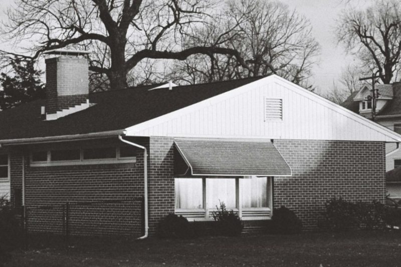 Classic brick house in Clinton, IL, surrounded by snow during winter.