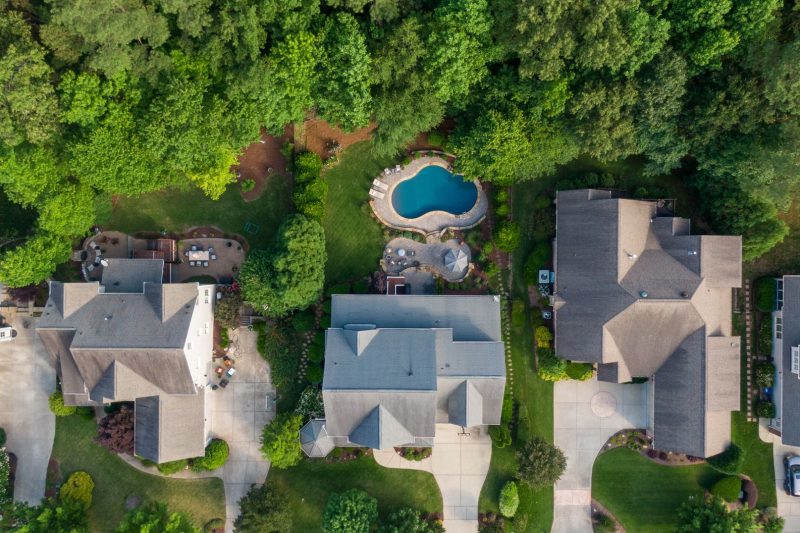 Aerial view of a Wake Forest suburb featuring lush green backyards and a swimming pool.