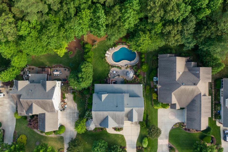 Aerial view of a Wake Forest, NC suburb featuring green backyards and a swimming pool.