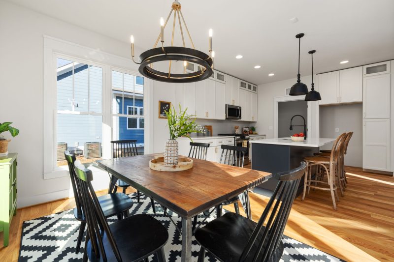 Bright, modern kitchen featuring stylish furnishings, a dining table, and abundant natural light.
